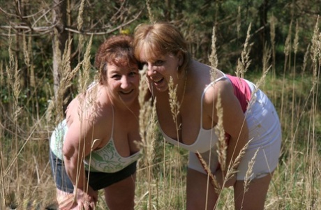 The big tits of an older lady named Kinky Carol and her partner are visible in the air near trees.