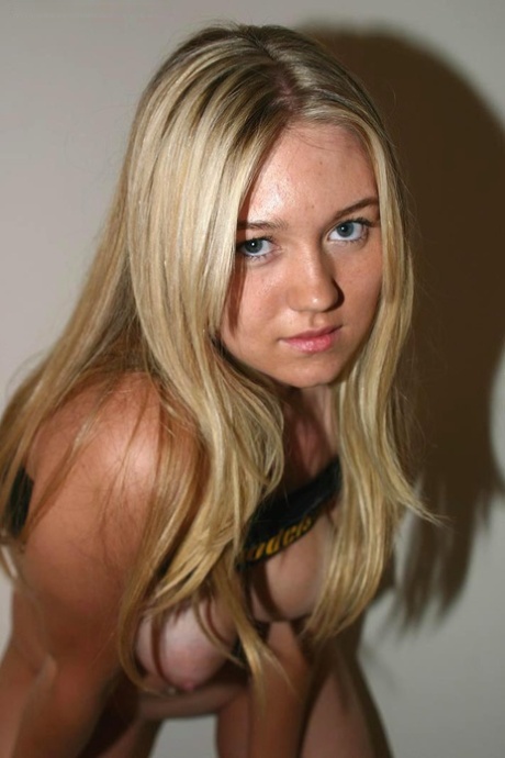 Following her nude modeling session, blonde Alison embraces a girlfriend with affection.