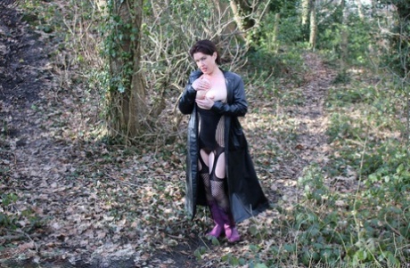 Young British woman Juicey Janet reveals her large breasts and pussy in the woods.