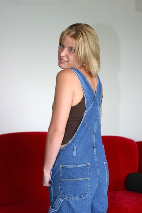 Devon, who has a blue-eyed expression and blonde hair, removes her overalls before modeling completely naked.