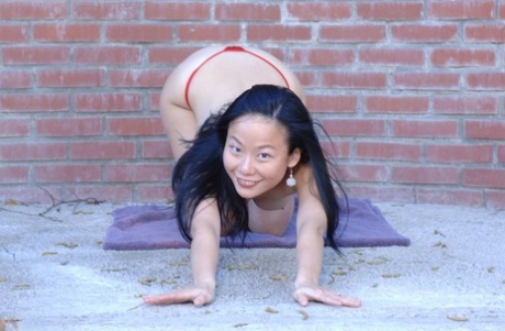 Niya Yu, an Asian who is new to the sport, removes her clothing and goes for a naked walk on a brick wall.