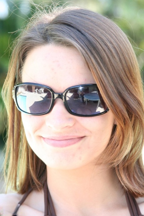 A naked amateur model named Bella Brooks models herself wearing a bikini and sunglasses.