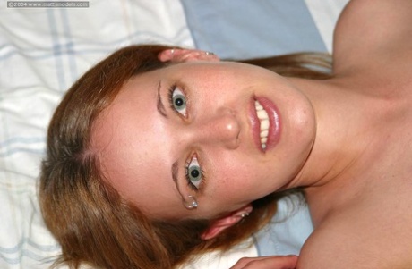 During her first nude shoot, Faye, the thin redhead, pins parts of her trimmed bush.