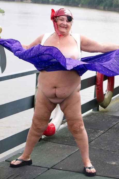 Fat British granny flaunts her pirate-emblazoned attire on a bridge.