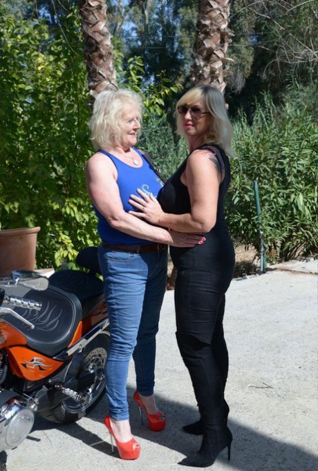 Full-skirt and fully clothed, mature blonde lesbians engage in boob tapping.