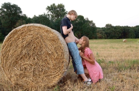 A round bale is used by a young couple to engage in sexual activity in a farmer's field.