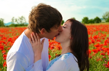 In a field of blooming flowers, a young couple engage in sexual activity.