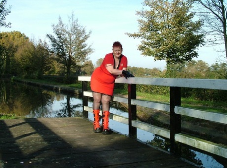 Exposed, a young redhead, exposes herself in punk boots on a footbridge.