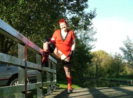 The adult Redhead Valgasmic Exposed puts her feet up on a footbridge while wearing a pair of punk boots.