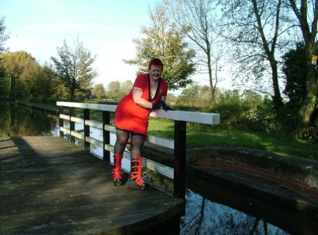 In her punk boots, Valgasmic Exposed bares her face while walking on a footbridge as a young redhead.