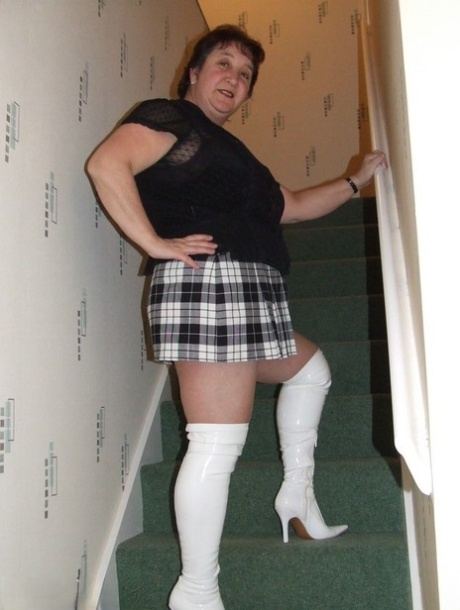 Mature BBW Kinky Carol gets naked in her underthings and OTK boots on stairs