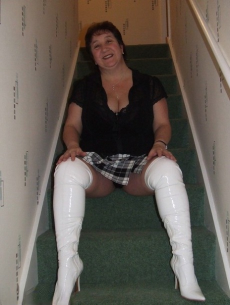 Mature BBW Kinky Carol gets naked in her underthings and OTK boots on stairs