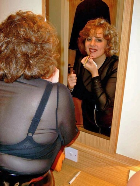 Curvy Claire, a redhead from the UK, exposes her lips to a mirror before giving a blowjob.