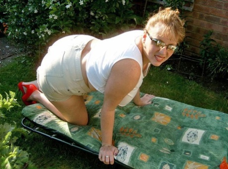 The dildo is used by UK amateur Curvy Claire to stimulate her breasts while sitting on a lawn chair.