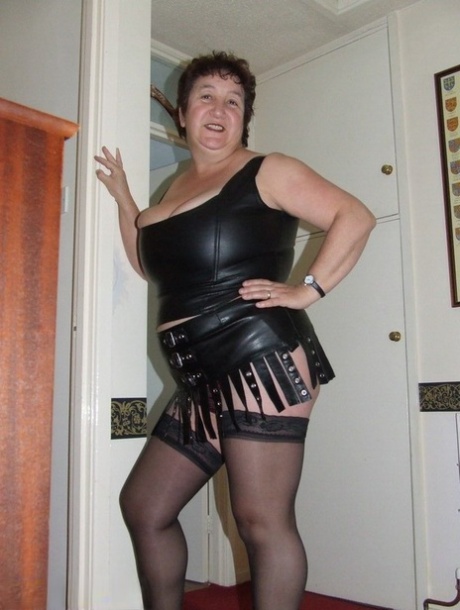 Youngster Kinky Carol removes her leather clothing to expose herself in stockings.