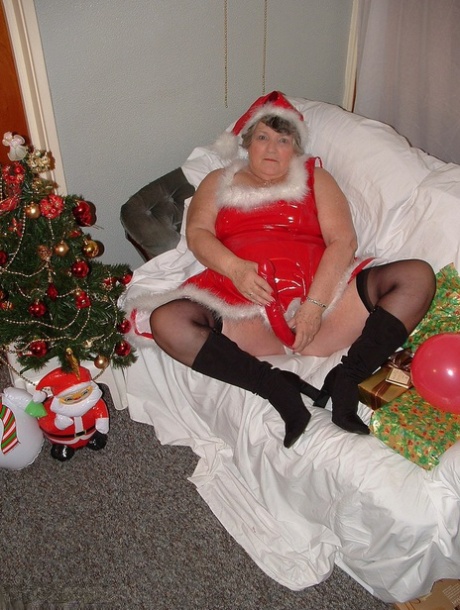 In the midst of Christmas, Grandma Libby plays music and cuddles with Santa on a covered couch.