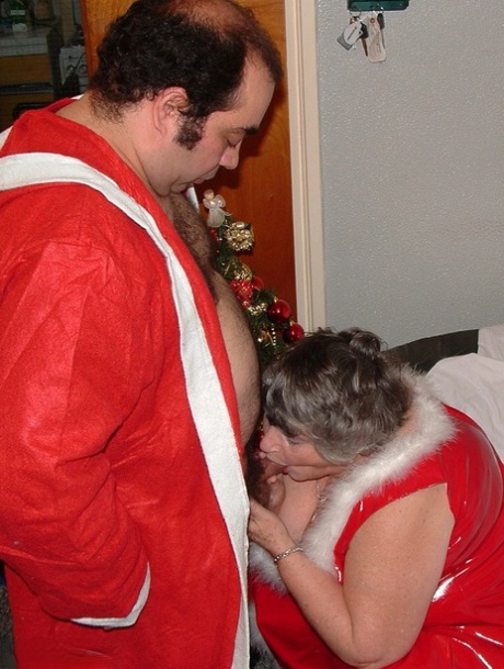 Santa Claus is entertained by Grandma Libby, who enjoys cuddling on a covered couch.