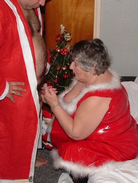 Grandmother Libby, who is both handsome and beautiful in appearances, plays with Santa while crawling on a covered couch.