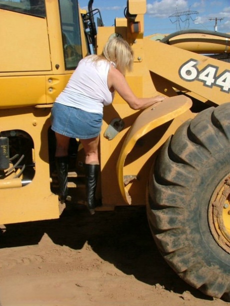 Overweight Adonna flaunts her body in front of heavy equipment.