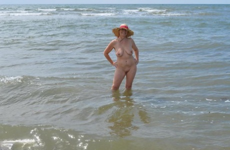 Despite being an older amateur swimmer, Barby Slut goes into the ocean wearing only her sunnies.