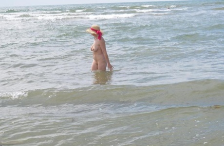 Wearing only a sun hat, Barby Slut, an older ex-parasite, ventures into the ocean.