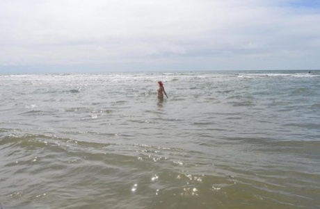 With just a sun hat, Barby Slut, an older ex-parasite, ventures into the ocean to swim.