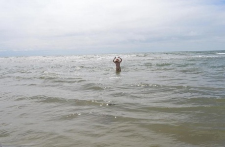 Barby Slut, an older ex-parachute, ventures into the ocean wearing only a sun bonnet.