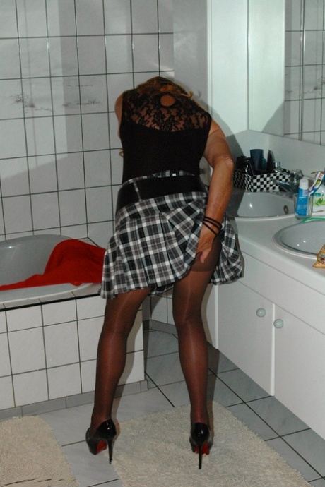 In the bathroom, Kyras Nylons, a young adult with freckles, puts her skirt on top of her pantyhose.