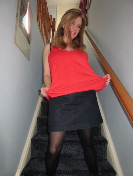 Lily May, the foxy MILF, spreads her large buttocks on the stairs.