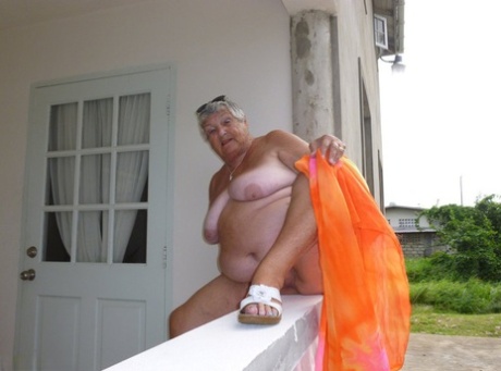 The overweight woman, Grandma Libby, flaunts her tanning on a balcony.