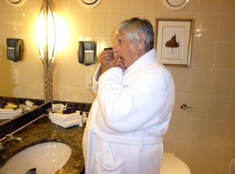 To be naked in a cupless bra, Grandma Libby removes her bathrobe for a nude photo.