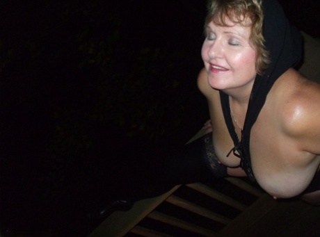 During the night, Busty Bliss, an older woman, exposes her big natural features on a deck.