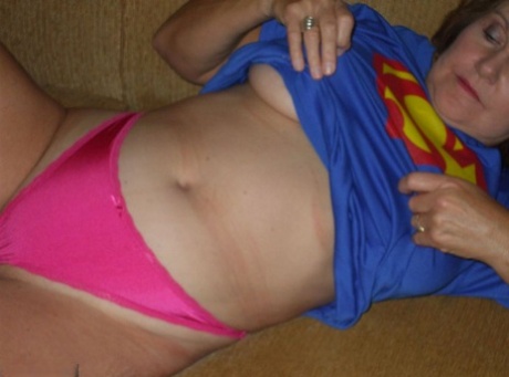 Big boob: The older Busty Bliss gets naked while wearing her Superman T-shirt.