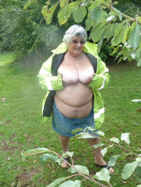 The obese British woman, known as Grandma Libby, exposes herself by standing near a tree in a park.