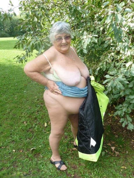 Grandma Libby, an overweight woman from Britain who is quite fit, stands by the edge of a tree in a park.