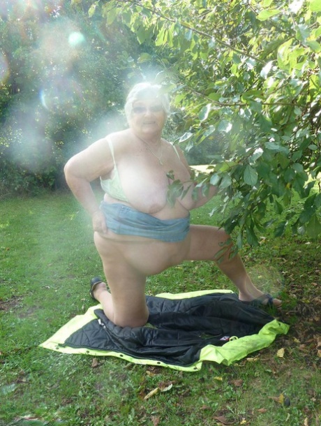 The overweight British lady, Grandma Libby (pictured), stands before the tree in an urban area.