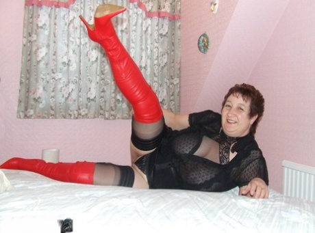 Nodded stockings and over the knee boots are worn by the plump mature woman, Kinky Carol.