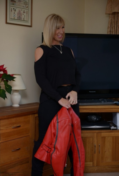 Melody, a mature blonde, exposes her massive breasts as she sews up in a thong.