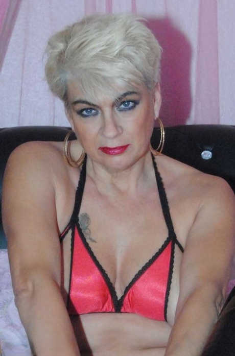 The platinum blonde Dimonty wears a daring bikini top and heels as she rubs her tongue.