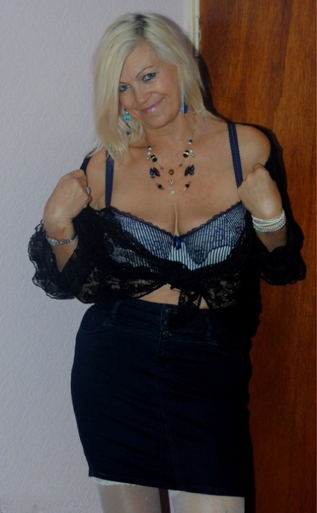 Aged platinum blonde undressing to wear her seductive lace lingerie.