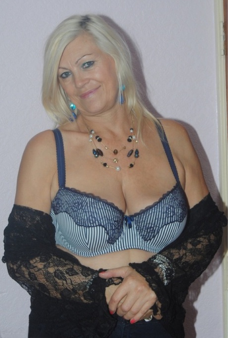 The elderly Platinum Blonde undressing for a photo in her seductively suggestive lace lingerie.