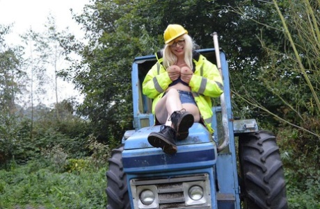 Barby Slut, who is a mature amateur, exposes herself on heavy equipment at a job site.