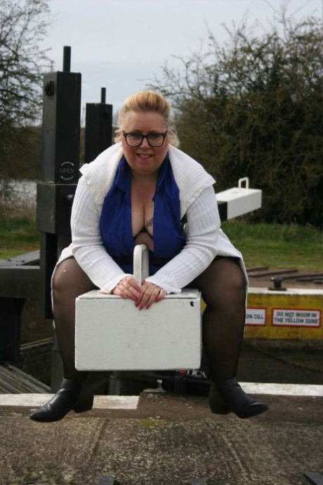 An overweight Englishwoman, Lexie Cummings (left) exposes her stomach and breasts near a lock.