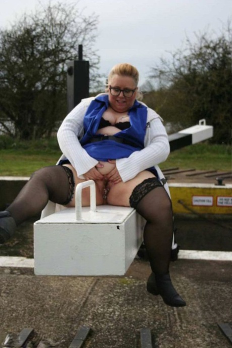 Lexie Cummings, an overweight UK amateur swimmer, displays her stomach and tail near a lock.