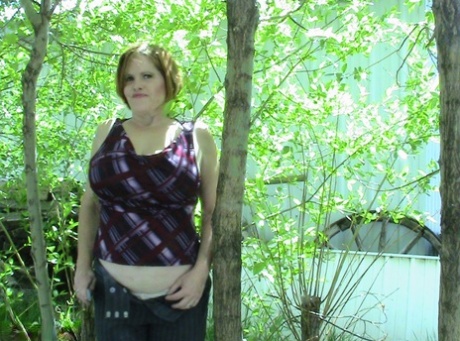 Long-staining woman Misha MILF stands and gazes into the distance from a line of hardwood trees.