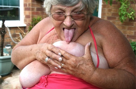 In front of the ring on an outdoor patio, Grandma Libby is seen kissing her buttocks and then baring her big ass against the wall with a nipple lick.