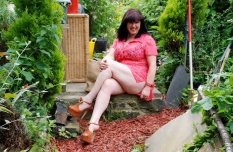 During her amateur years, Juicey Janey displays her large tits and buttocks in the garden.