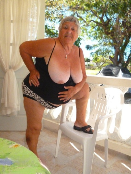 On a balcony alone, Grandma Libby appears nude and full of herself.