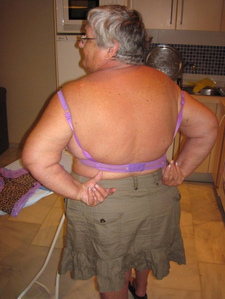 Great Britain's oma, Grandma Libby, who is overweight, displays her breast tissue while ironing.