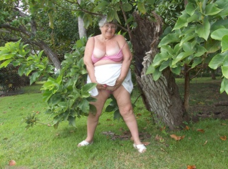 A tree beneath the limbs of Grandma Libby, an elderly woman from Britain, is revealed as she displays her large breasts.